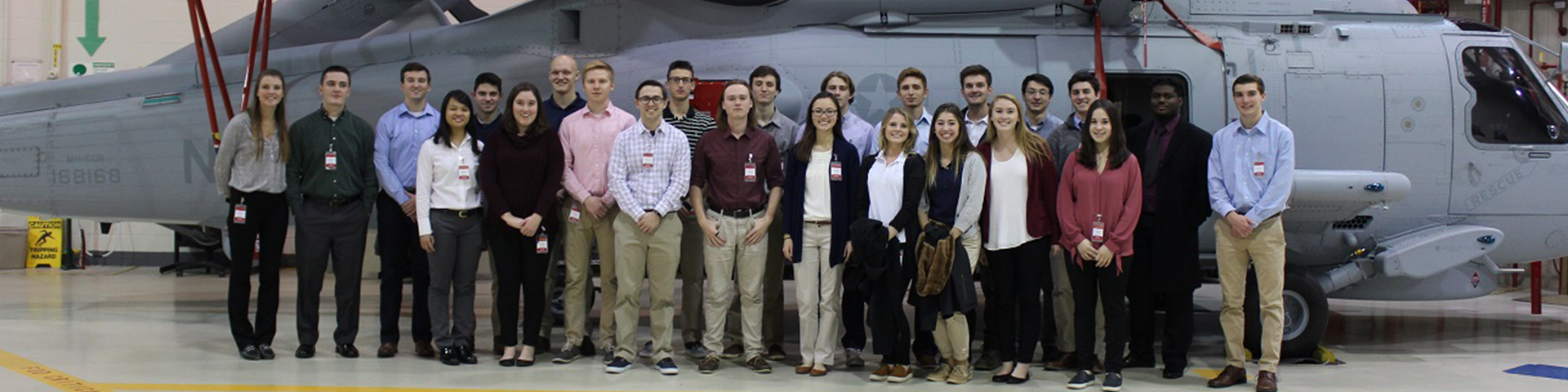 Group of people stand in front of a helicopter