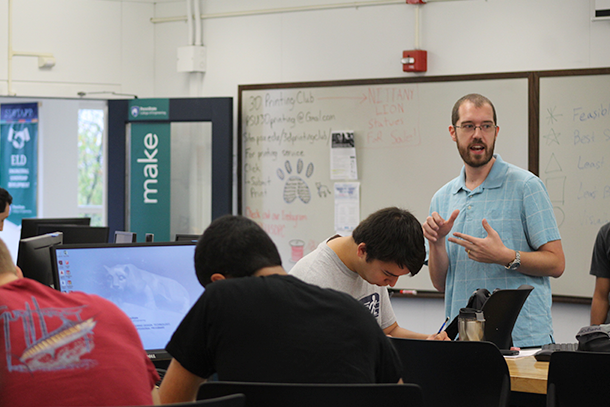 Man stands in front of classroom, speaking to students