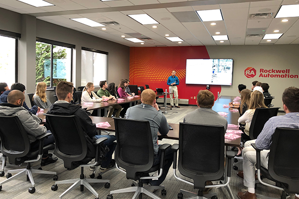 People sitting around a table listening to a speaker talk