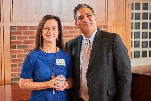 Woman in blue shirt standing with a man in a suit