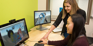 a professor and a student discuss a project while looking at a computer screen