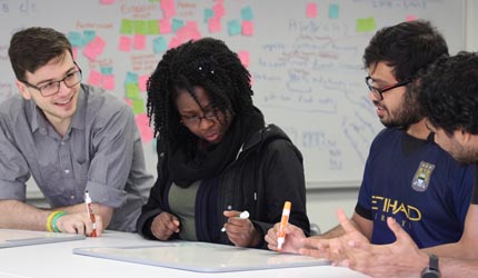 four students collaborate on an assignment